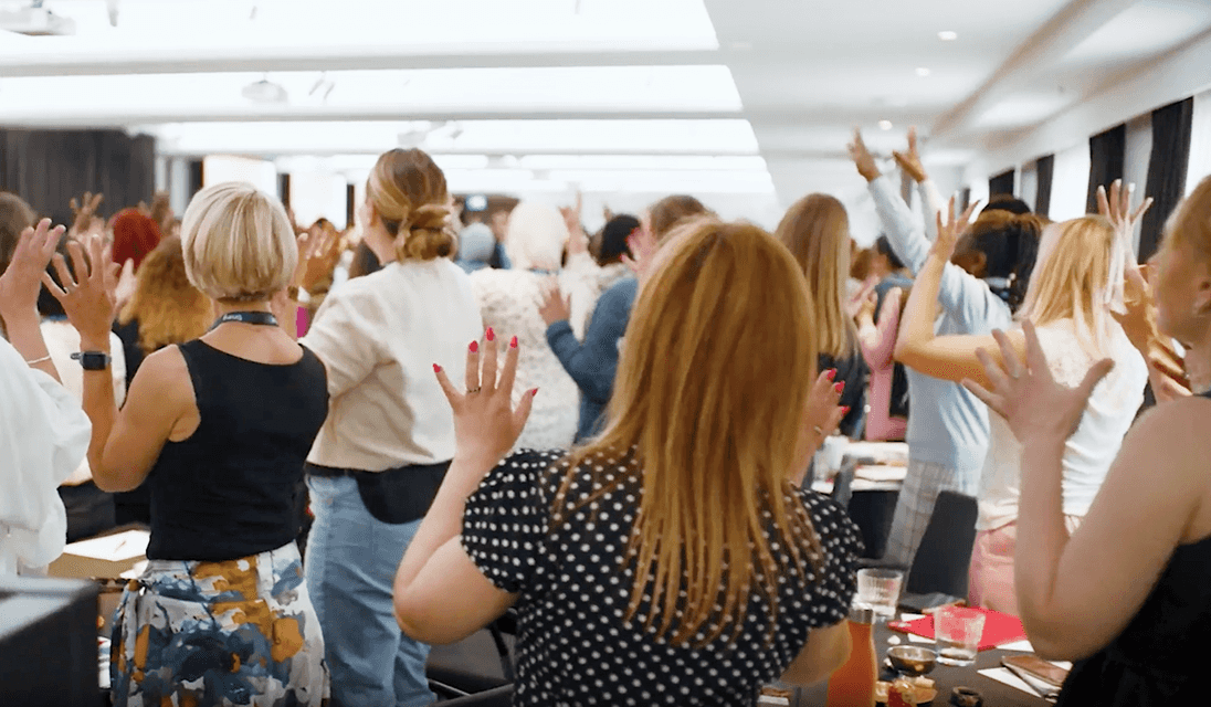 Thumbnail of a video from the 2025 Community Conference, audience standing and silently applauding