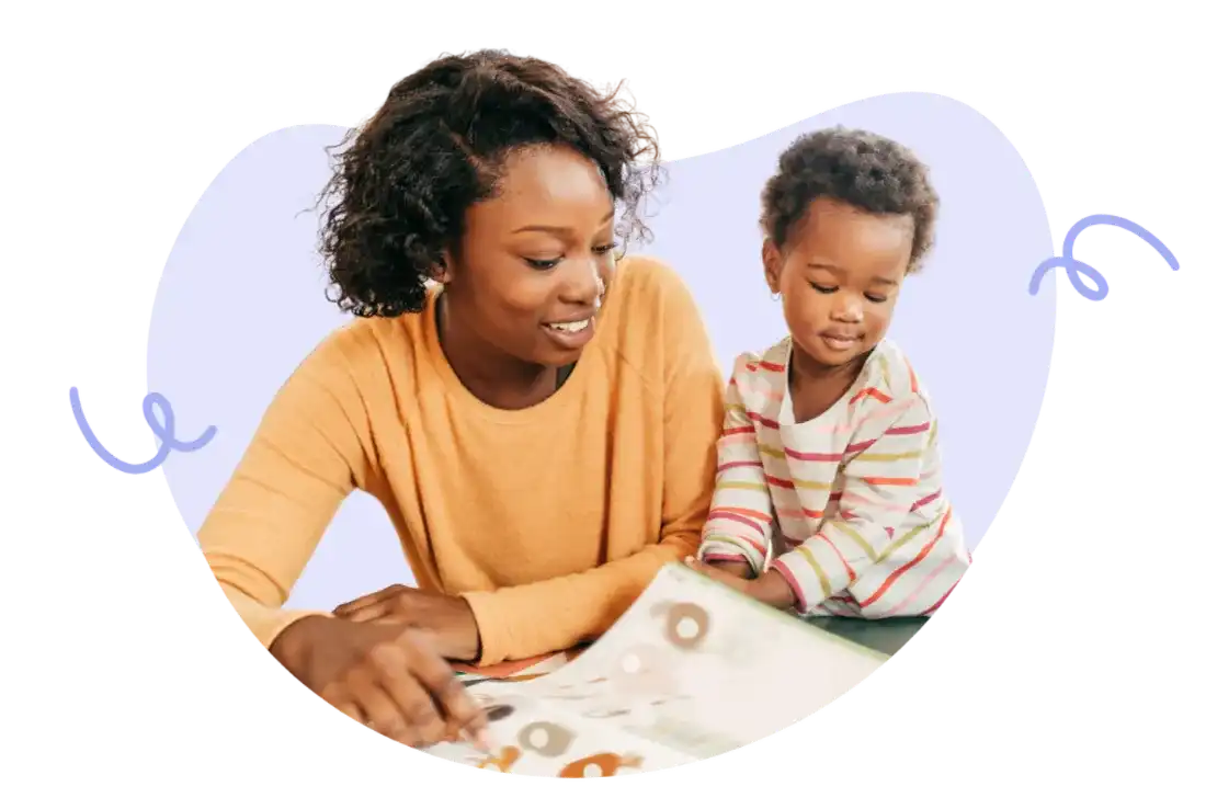 A tiney childminder reading a book with a young child